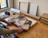 A canvas print being prepared for packing in the workshop